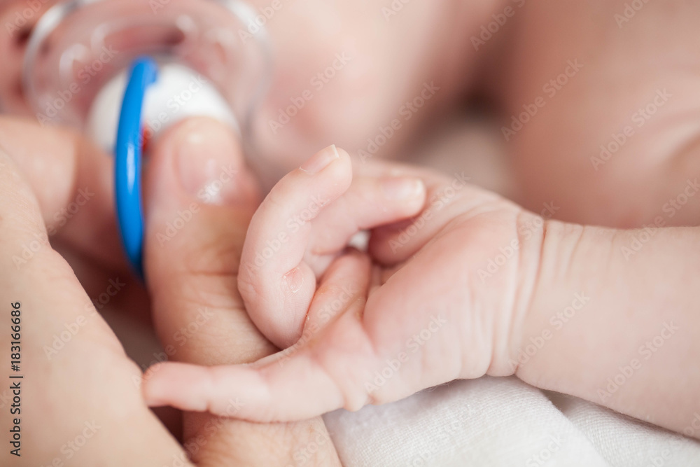 Hand the sleeping baby in the hand of mother close-up. Hand the sleeping baby in the hand of mother close-up.