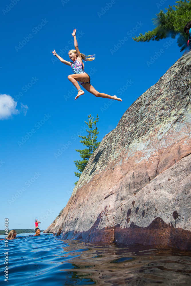 Kids jumping into the river during a camping trip