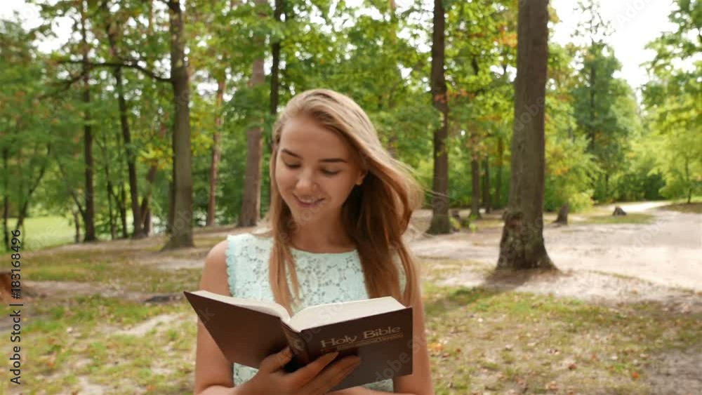 4k.Young modern girl walk with Bible in park. Christian team shot 4k.Young modern girl walk with Bible in park. Christian team shot