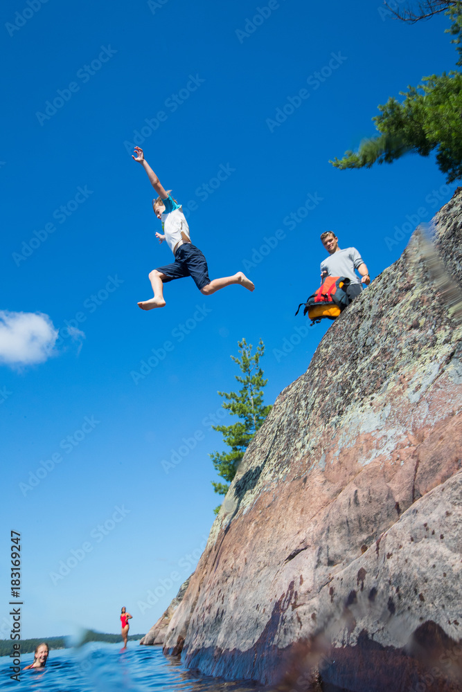 Kids jumping into the river during a camping trip