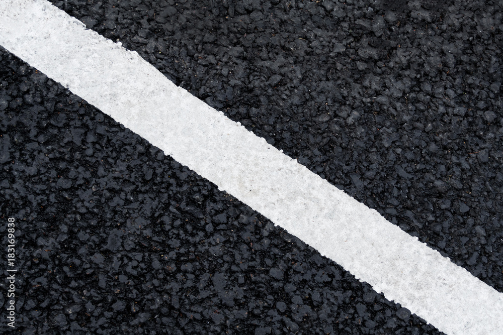 Fototapeta premium White diagonal marking line on the asphalt road (background, texture, abstract)