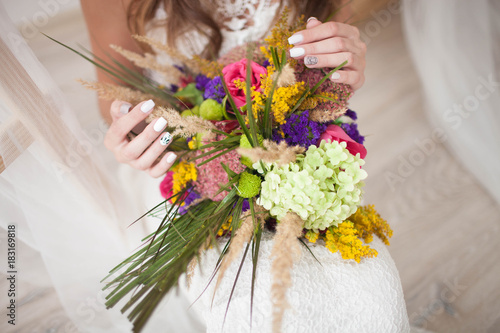 beautiful wedding bouquet with roses in bride's hands.