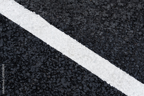 White diagonal marking line on the asphalt road (background, texture, abstract) © Mikhail