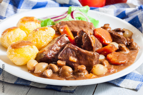 Beef Bourguignon stew served with baked potatoes