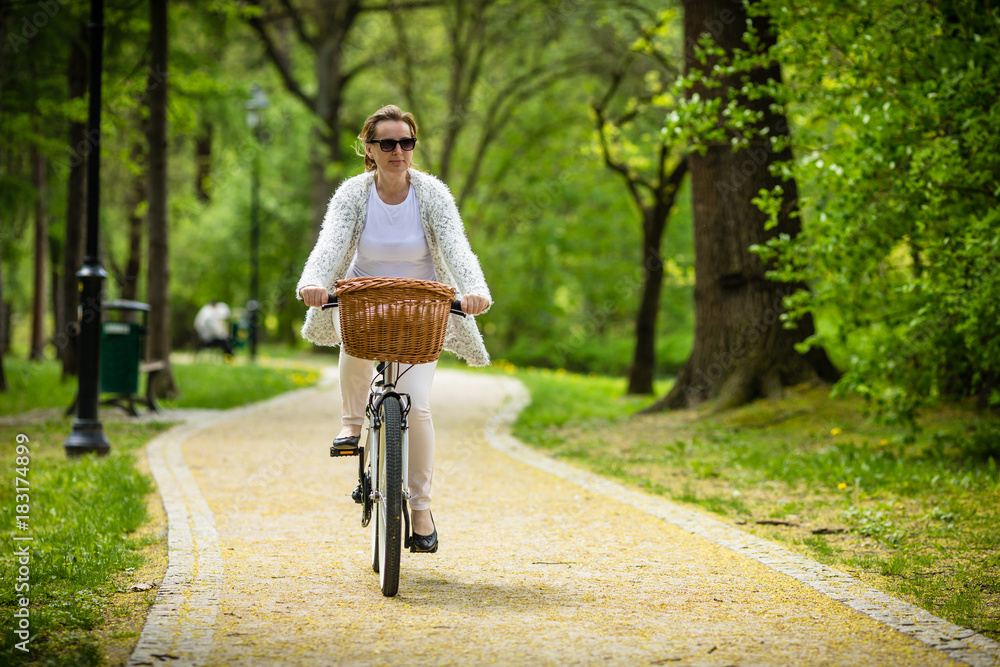 Obraz premium Urban biking - woman riding bike in city park 