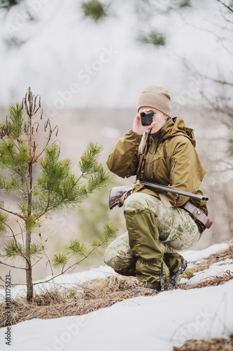 female hunter ready to hunt, holding laser finder in forest. hunting and people concept