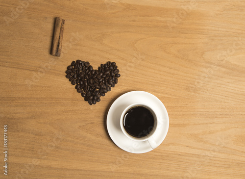 I love coffee with coffee beans  a cinnamon stick and black coffee on a wooden background 