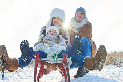 Glückliche Familie beim rodeln im Winter photo