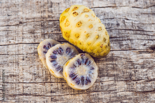 fresh noni fruit and noni slice on wooden background and space.slice of noni fruit with space on wooden background photo