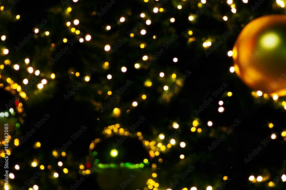 Obraz premium Small light yellow dot bokeh and shiny ball in dark night on Christmas season , celebrate festival, greeting, star