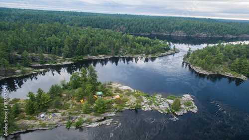 Aerial view of camping on the edge of a river during a family canoe trip