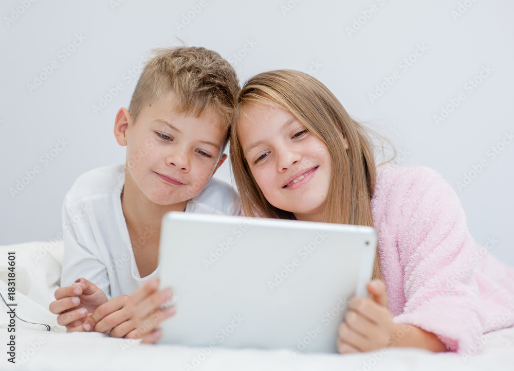 happy children with tablet computer on the bed happy children with tablet computer on the bed