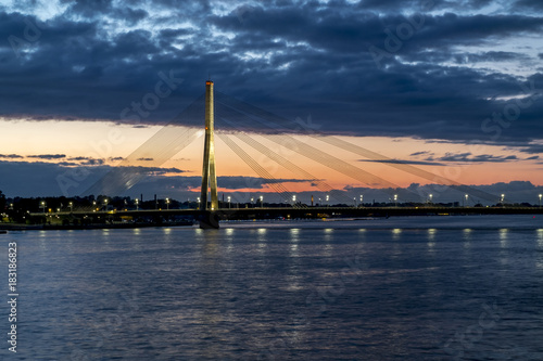 View of the cable-stayed bridge and the embankment of the river Daugava in Riga at sunset.