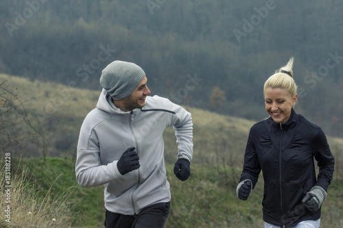 Young couple jogging in nature at cold day