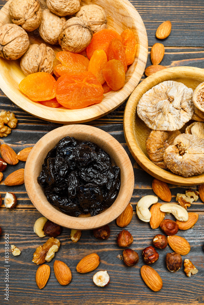 dried fruits figs, apricots, plums and nuts on wooden background dried fruits figs, apricots, plums and nuts on wooden background