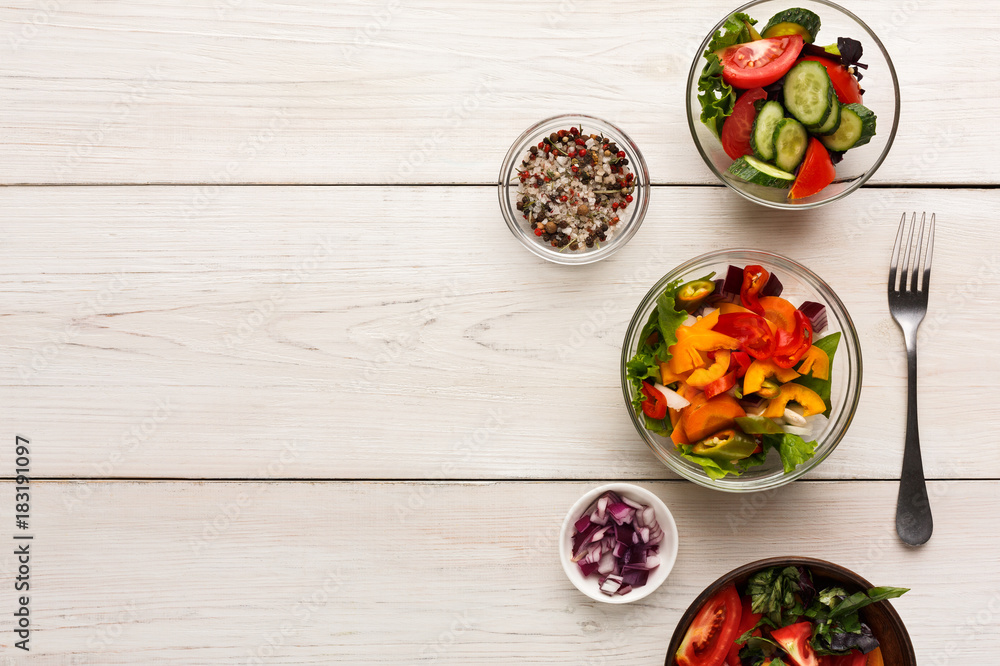 Various salad bowls on white wooden table, top view Various salad bowls on white wooden table, top view