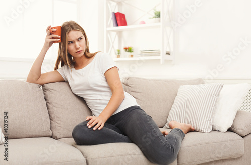 Thoughtful woman at home with coffee