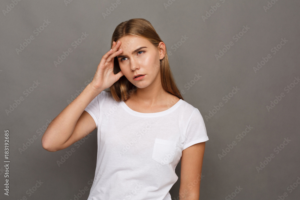 Concentrated woman thinking on gray background Concentrated woman thinking on gray background