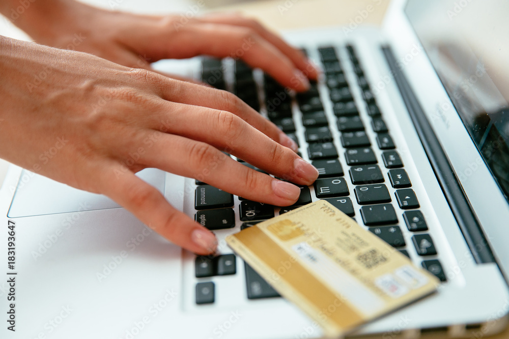 Woman makes online order in internet shop using laptop and paying by credit card Woman makes online order in internet shop using laptop and paying by credit card