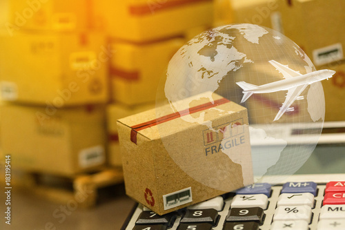 small papers boxes and calculator with a plane flies above world map. For ideas about transportation, international freight, global shipping, overseas trade, regional ,local forwarding.
