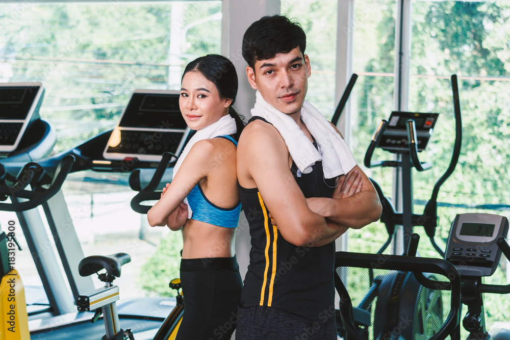 Fototapeta premium Sport man and woman with towel stand at the gym.fitness and lifestyle concept