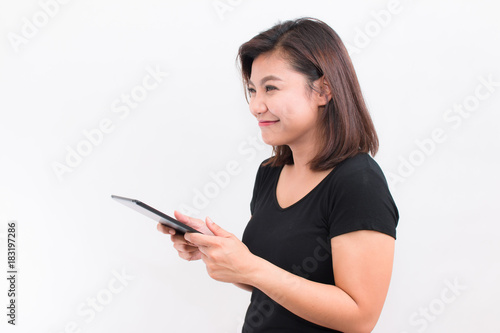 Beautiful Asian woman holding tablet. her looked at tablet and have happy smile on white background.