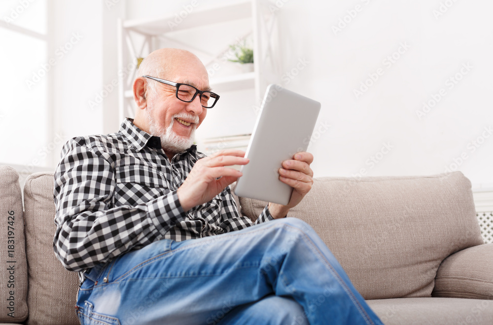 Senior man reading news on digital tablet Senior man reading news on digital tablet