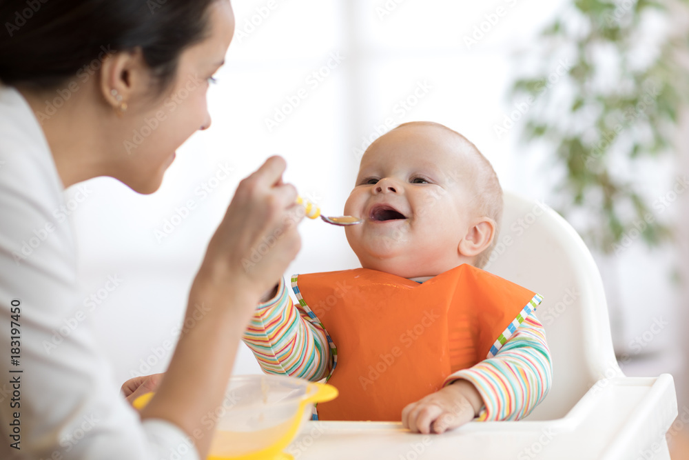 Mother Feeding Her Baby With Spoon Mother Giving Healthy Food To Her mother-feeding-her-baby-with-spoon-mother-giving-healthy-food-to-her