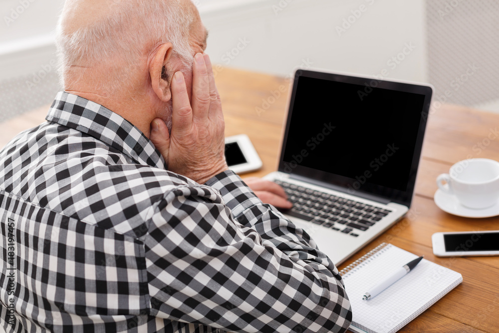 Senior man using laptop with blank screen mockup Senior man using laptop with blank screen mockup