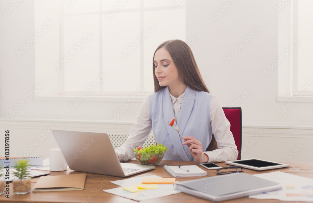 Young business woman eating salad at office Young business woman eating salad at office