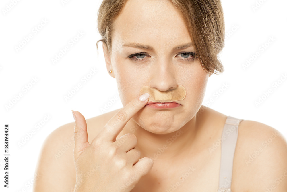 portrait of a young woman with a plaster under the nose portrait of a young woman with a plaster under the nose