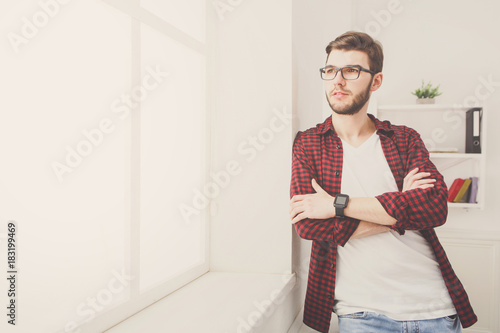 Confident young businessman at office near window
