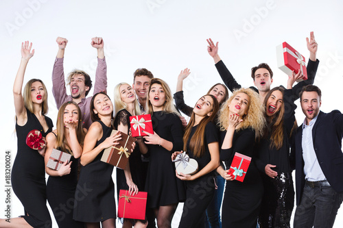 Group of young beautiful people in stylish clothes with gift boxes in hands having fun.