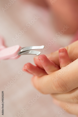 Mother cutting baby nails