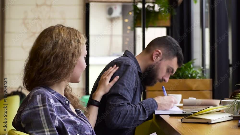 Slow motion of girl shows a guy interesting article in a book sitting in a cafe Slow motion of girl shows a guy interesting article in a book sitting in a cafe