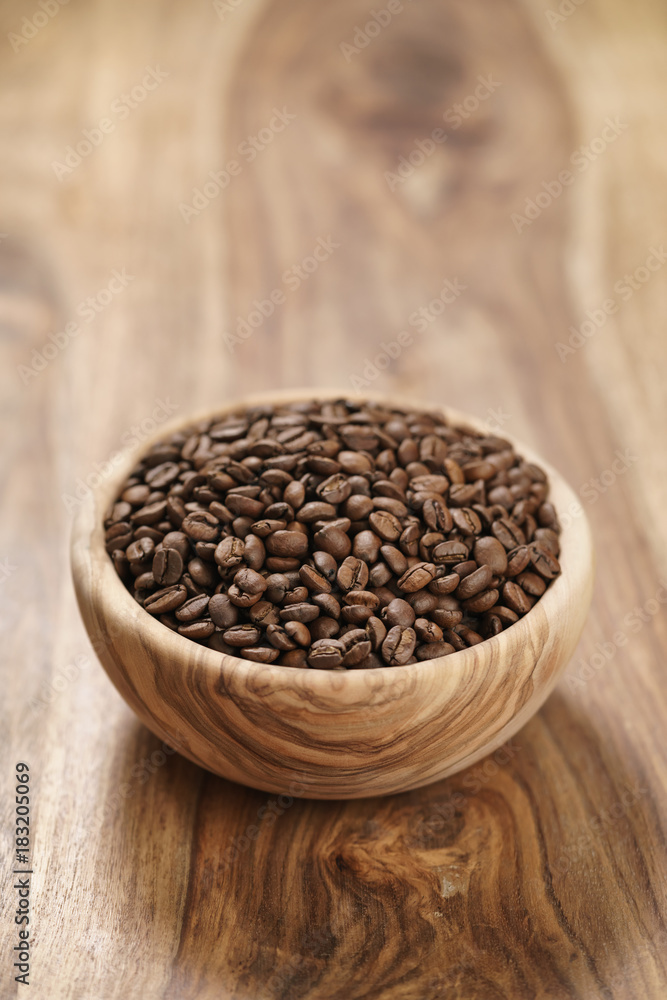 fresh roasted coffee beans in wood bowl on table fresh roasted coffee beans in wood bowl on table