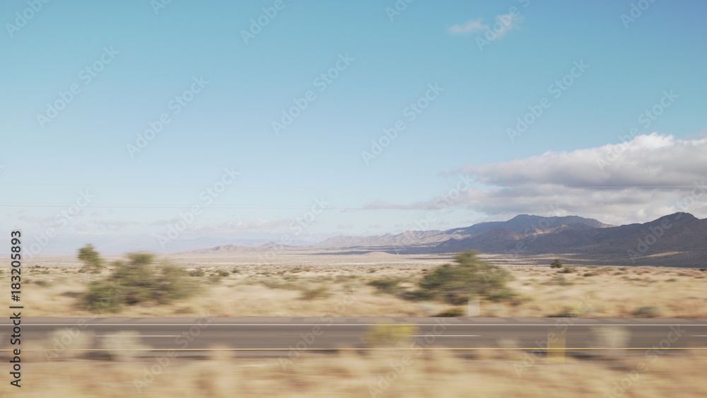 Driving plate side view moving through desert in car with motion blur