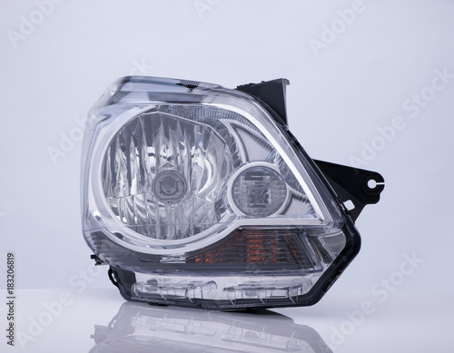 closeup of a car headlight on white background with reflection. isolated