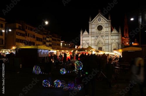 Florence 2 December 2017: Christmas Market in the Centre of Florence. The Lights of Christmas Market in Piazza Santa Croce and the Basilica of the Holy Cross on the Background. Florence, Italy. photo