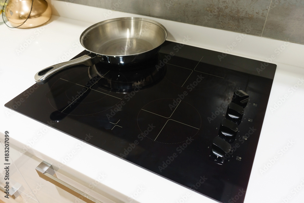 Metal Pot and pan on induction hob in modern kitchen. modern kitchen pot cooking induction electrical stove hob concept Metal Pot and pan on induction hob in modern kitchen. modern kitchen pot cooking induction electrical stove hob concept