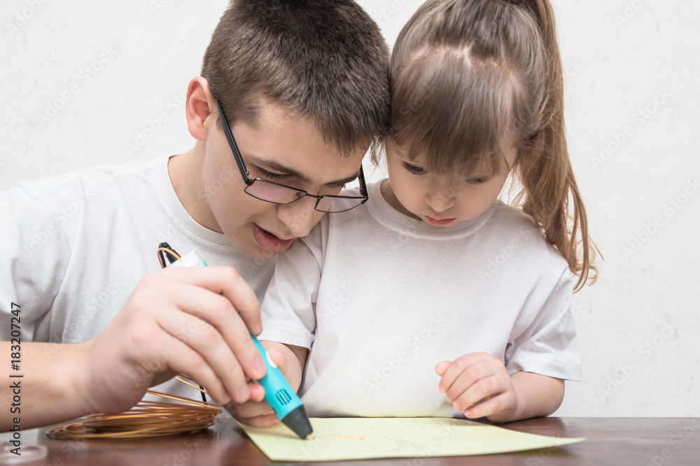 Teenager boy and cute little girl draw different things by 3d pen with a gold plastic handle. Mathematics. Engineering. Technology. Robotics. STEM education. Teenager boy and cute little girl draw different things by 3d pen with a gold plastic handle. Mathematics. Engineering. Technology. Robotics. STEM education.