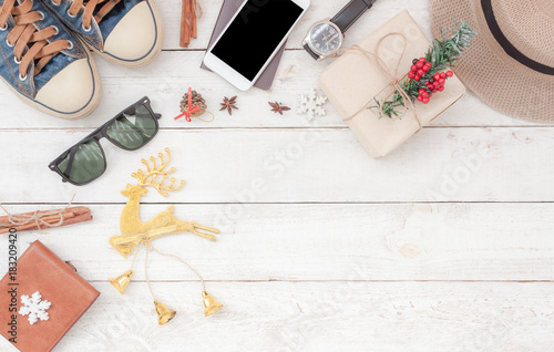 Table top view aerial image of accessories to travel on Merry Christmas & Happy New Year trip background concept.All object on modern rustic white wooden at home office desk studio.Free space for text