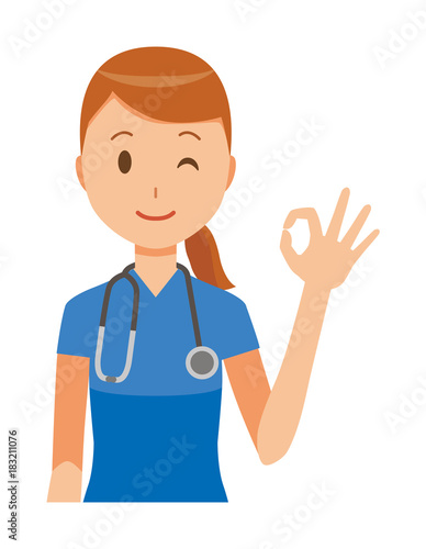 A female nurse wearing a blue scrub is doing an okay sign