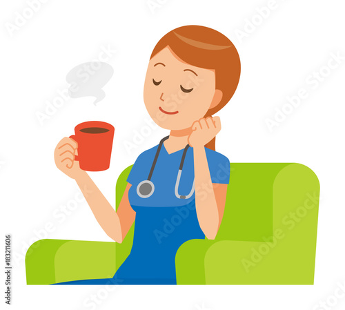 A woman nurse in a blue scrub is sitting on a sofa and drinking coffee