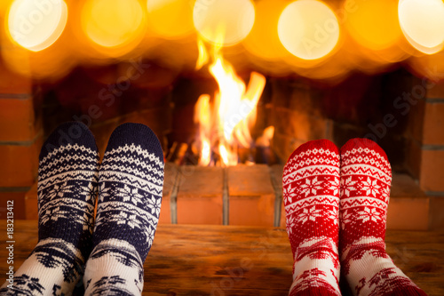 Couple in Christmas socks near fireplace © Sunny studio