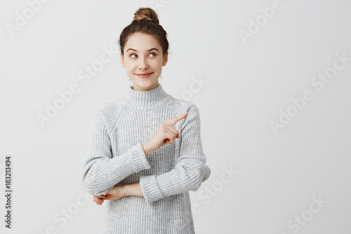 Photography Pretty brunette woman posing on camera with tricky look and gesturing to side
