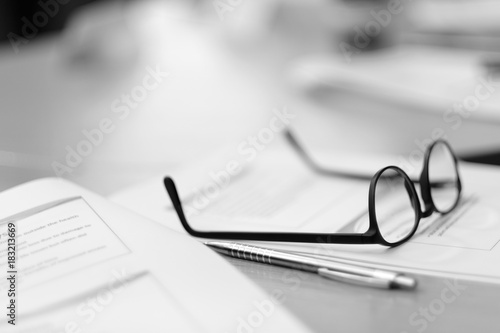 Glasses with a black frame lie on the desk in the office