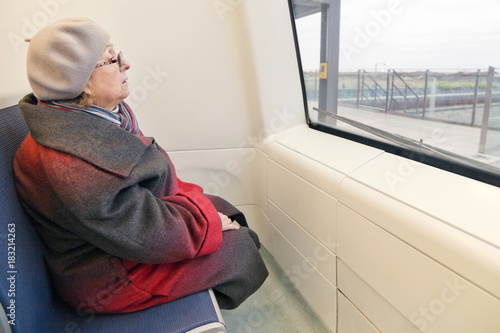 Пожилая женщина в первом вагоне поезда метро, беспилотное, автоматизированное управление © lisaveya
