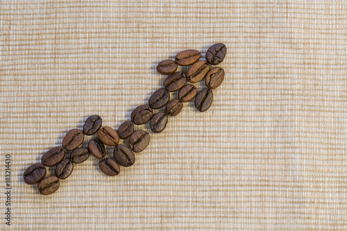 Coffee beans are laid out as a graph rising up on a beige napkin.