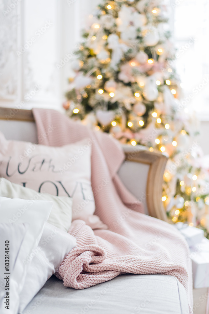 Knitted plaid and pillows on a sofa at home on a christmas eve. Home cosiness Knitted plaid and pillows on a sofa at home on a christmas eve. Home cosiness